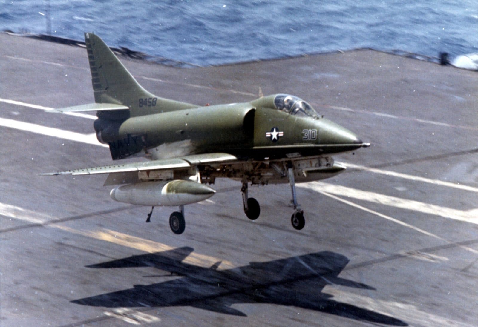 Skyhawk about to touch down on carrier.