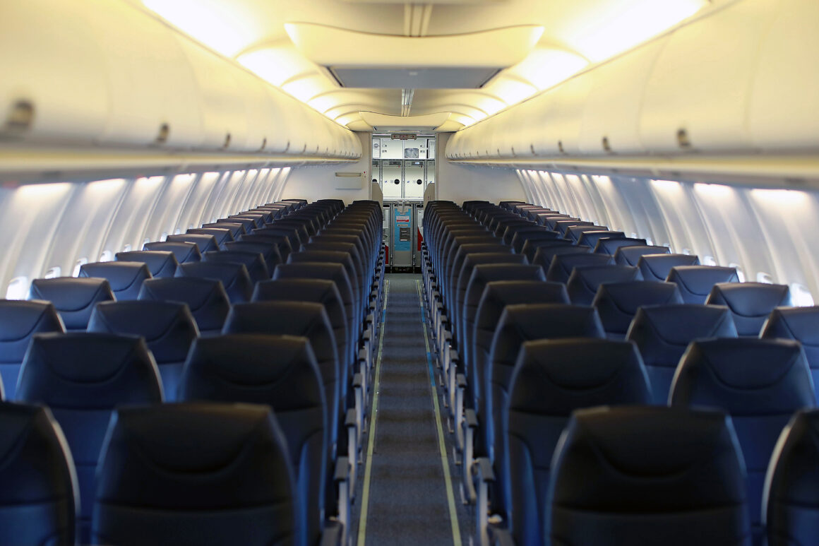 Interior of Avelo Airlines Boeing 737, looking aftward down center aisle.