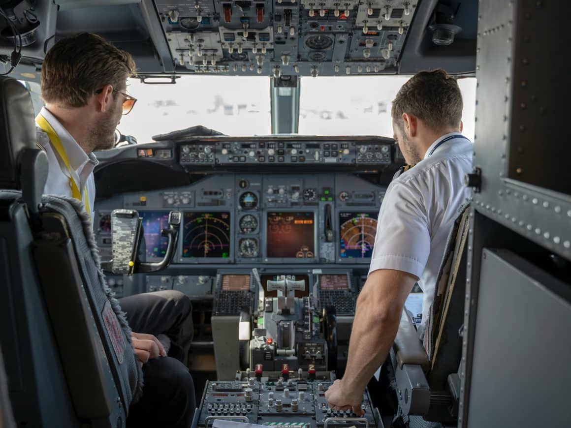 Two pilots in a cockpit prepare for another flight.