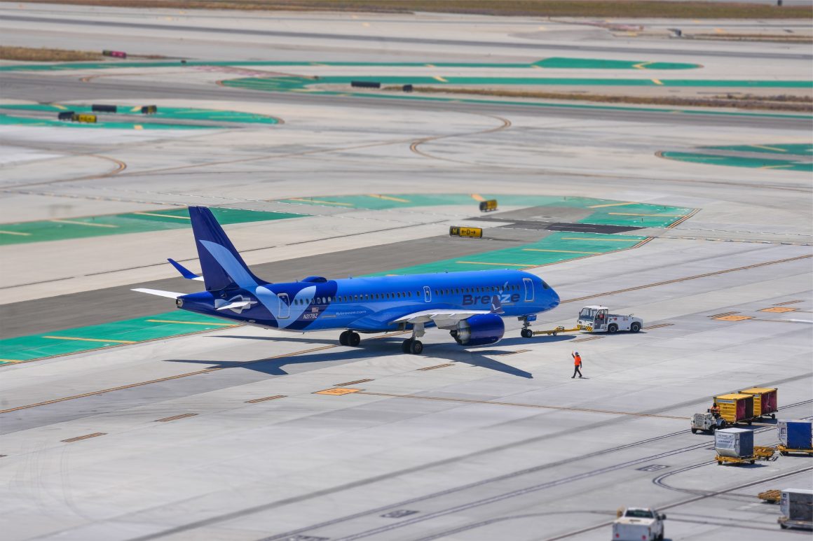 A Breeze Airways Airbus A220-300 pushes back at LAX 