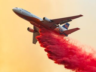 Tanker 914 of 10 Tanker Air Carrier dumps retardant on a fire