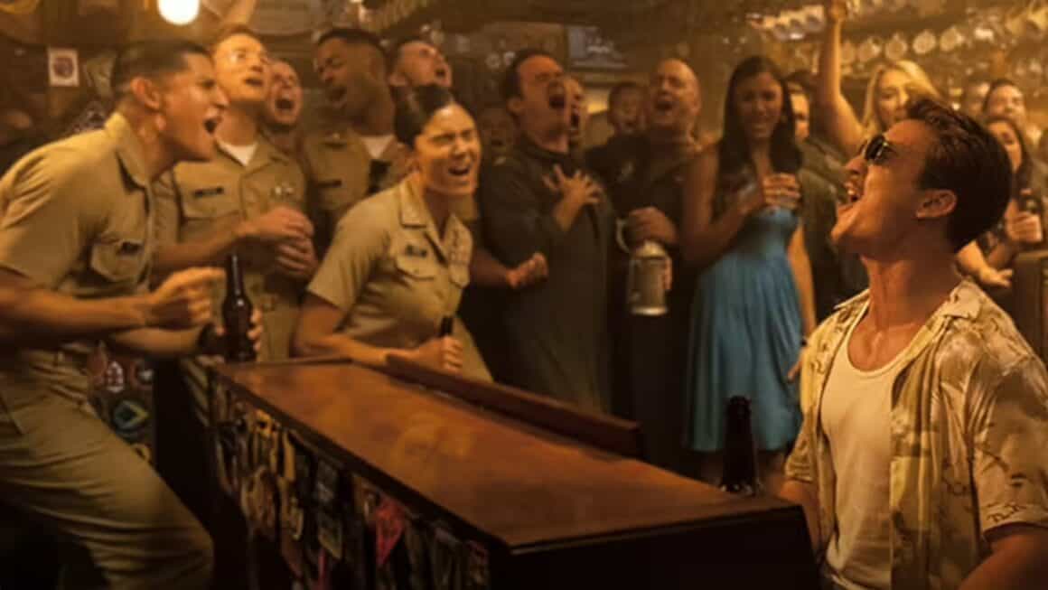 Rooster jamming on the piano with fellow Naval aviators at the Hard Deck bar in Top Gun: Maverick. 