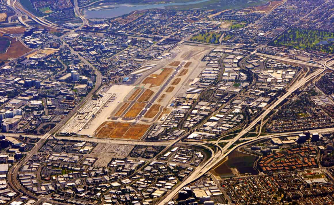 An aerial view of John Wayne Airport (SNA) in Orange County, California, showing just how densely populated the surrounding area is to the airport. The airport's proximity to such densely populated areas has led to the creation of the John Wayne Airport Fly Friendly program.