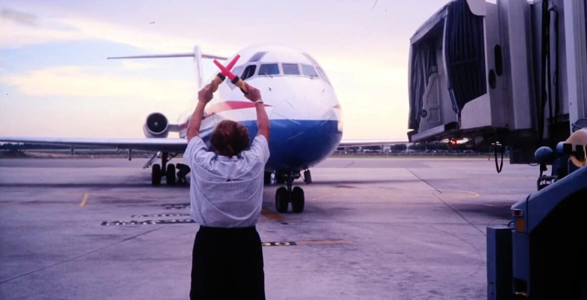 A Spirit employee marshals a Spirit DC-9 to the gate at ACY 